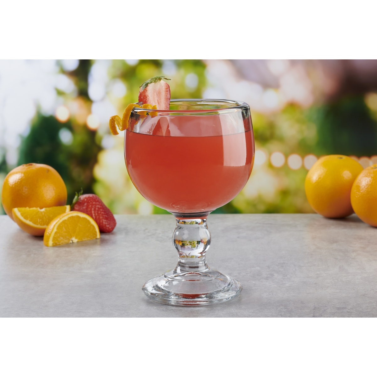 Anchor Hocking 18 oz. Weiss Goblet filled with a pink cocktail garnished with strawberry and orange twist