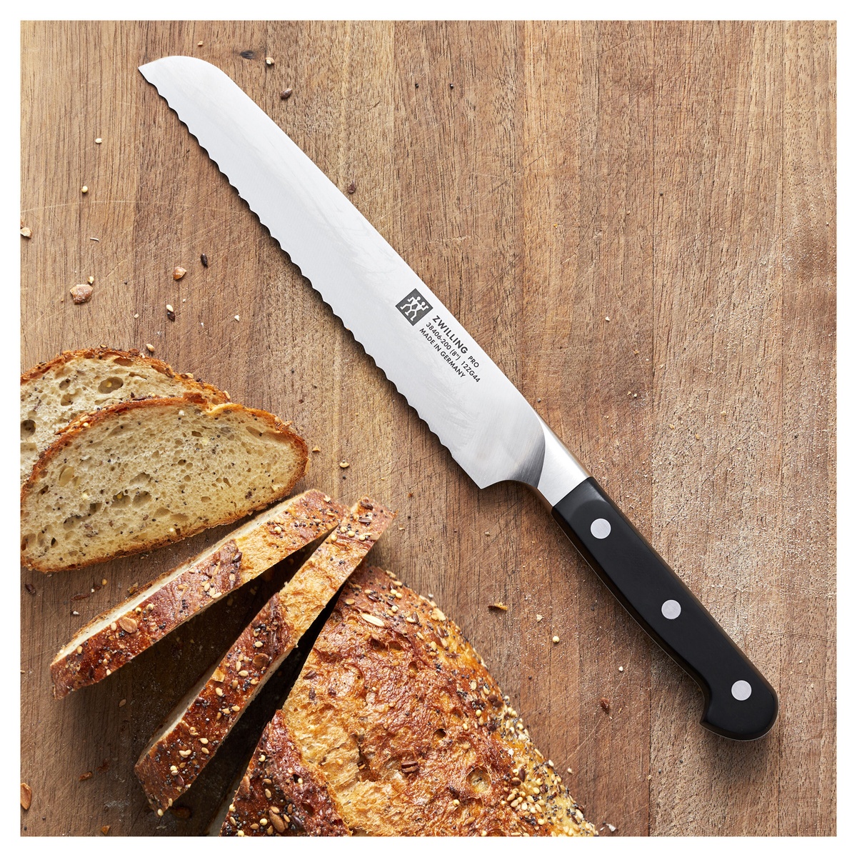 Zwilling Pro 8 inch bread knife on a wooden board with sliced bread
