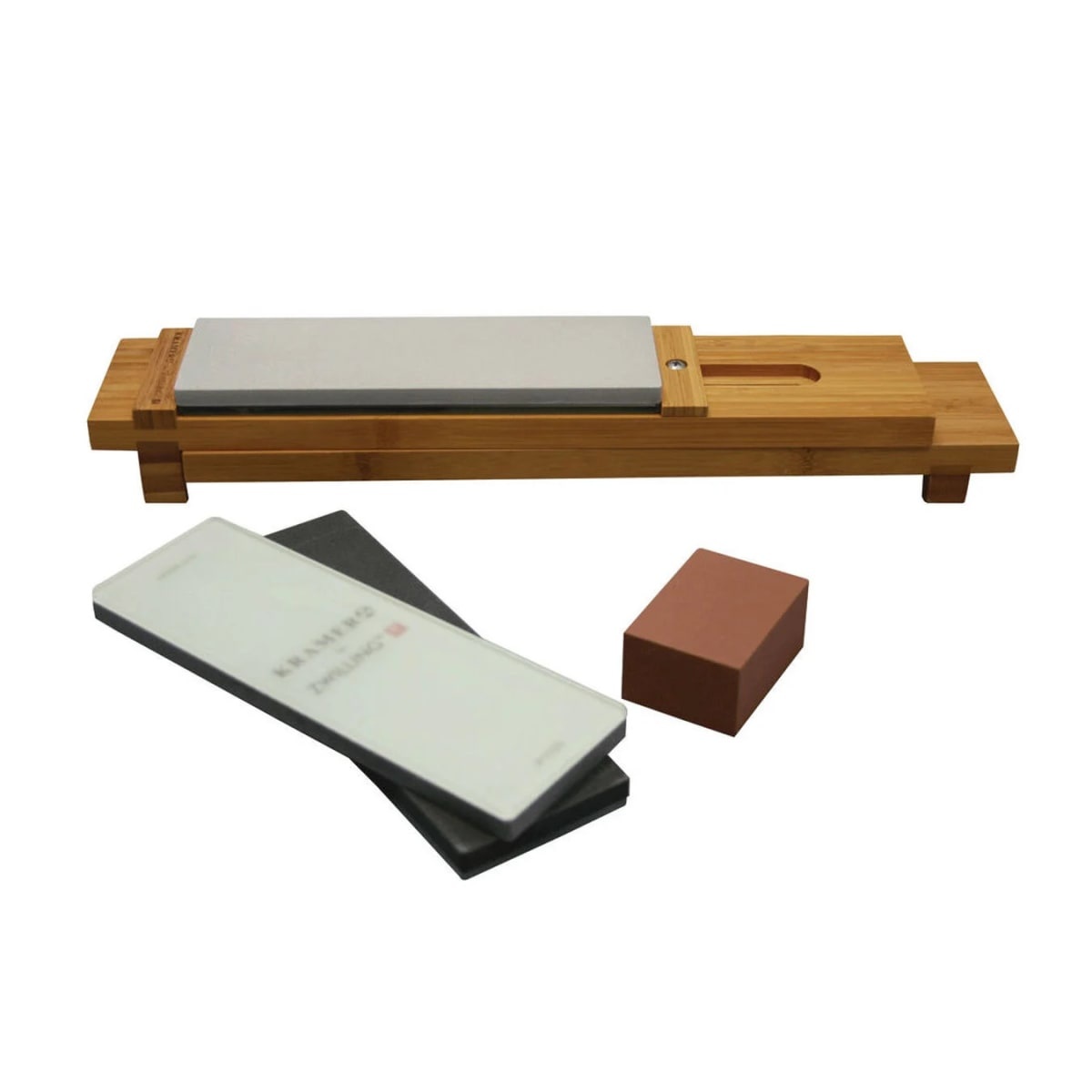 Zwilling Kramer 6-piece glass water stone sharpening set showing bamboo sink bridge with mounted stone, two stacked sharpening stones, and a cleaning block