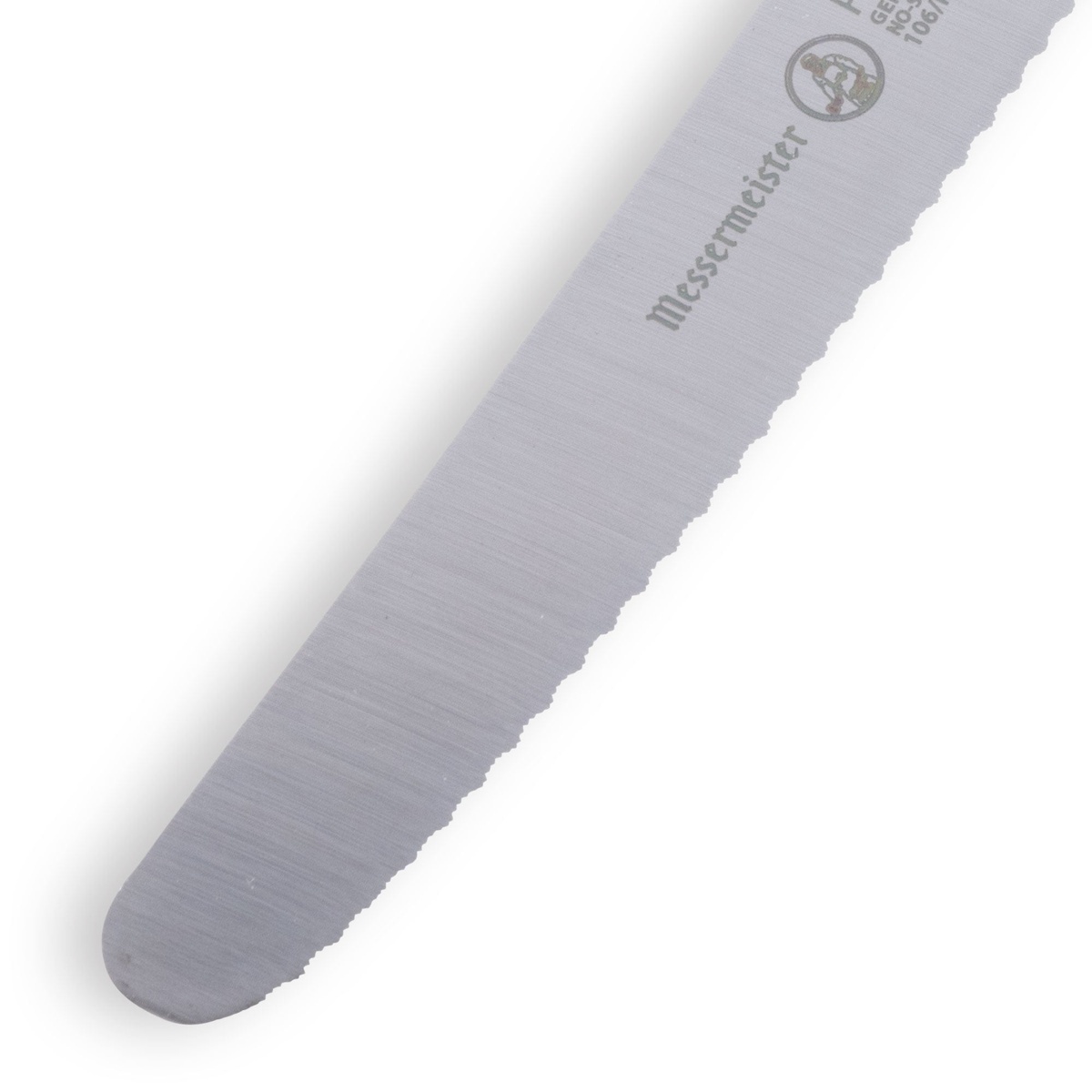 Close-up detail of the Messermeister Petite Messer serrated blade tip showing micro-serration pattern and Messermeister branding