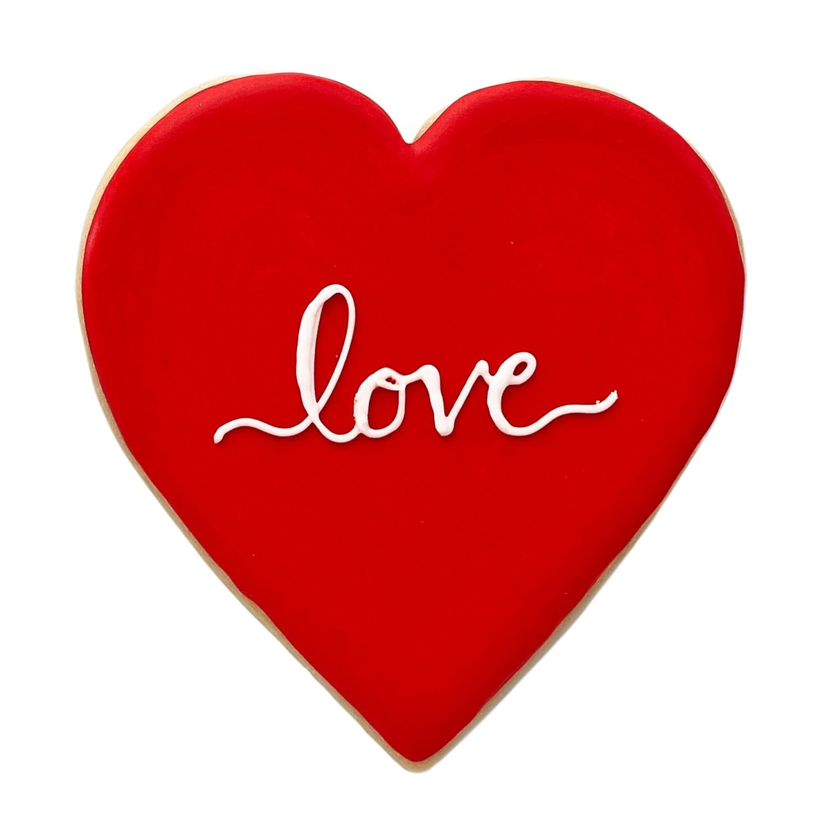 Close-up of a finished extra-large red heart-shaped sugar cookie with white 'love' royal icing script