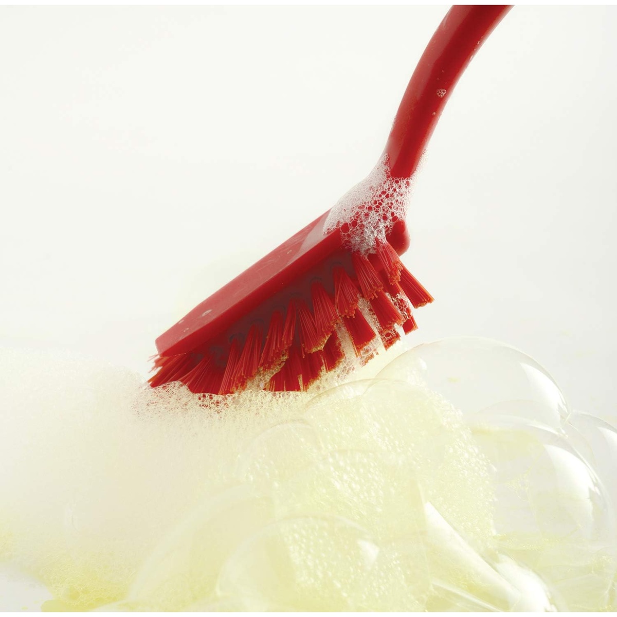 Close-up of Norpro 1088R red scrub brush bristles lathered in soapy foam during active scrubbing