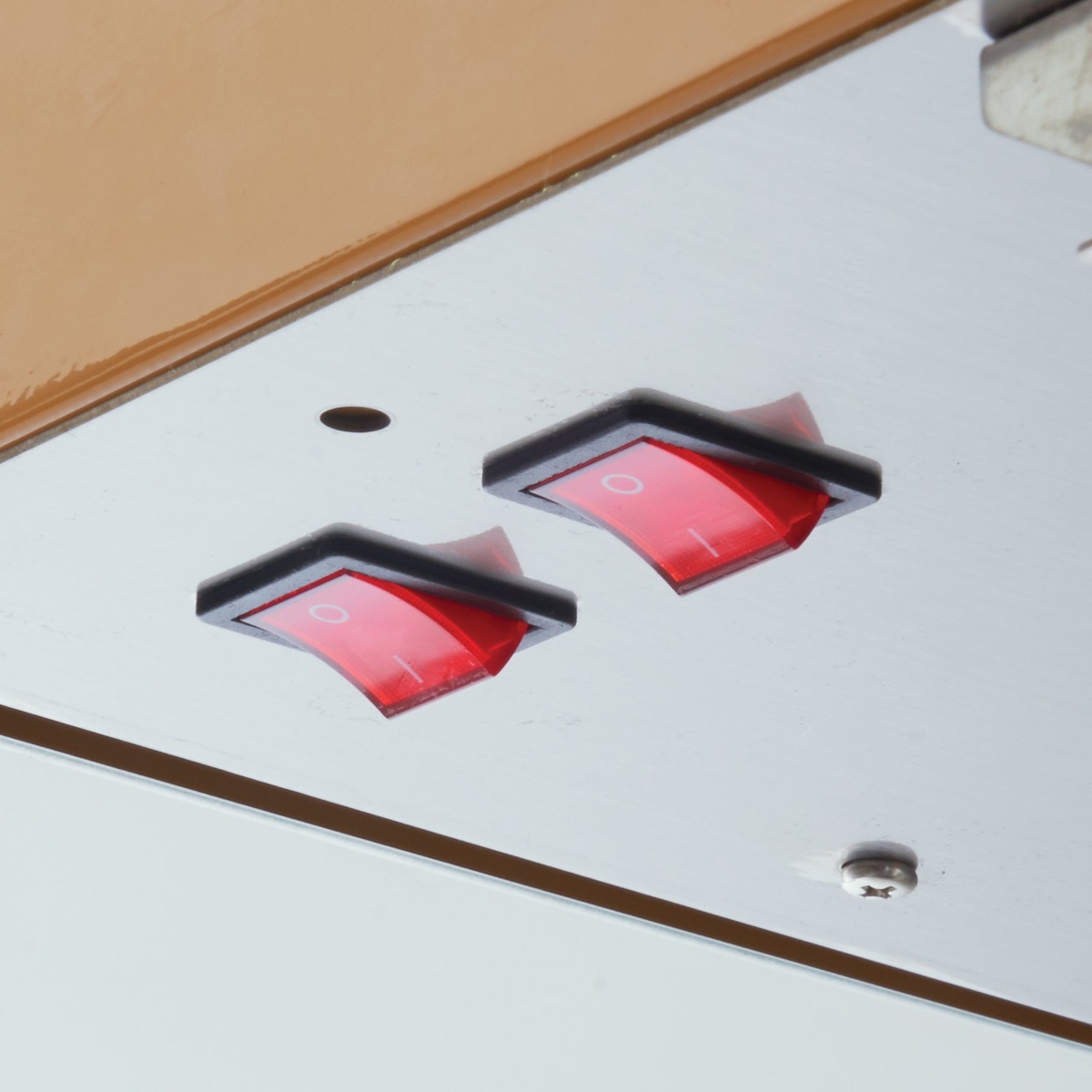 Close-up of two red rocker switches on popcorn machine control panel