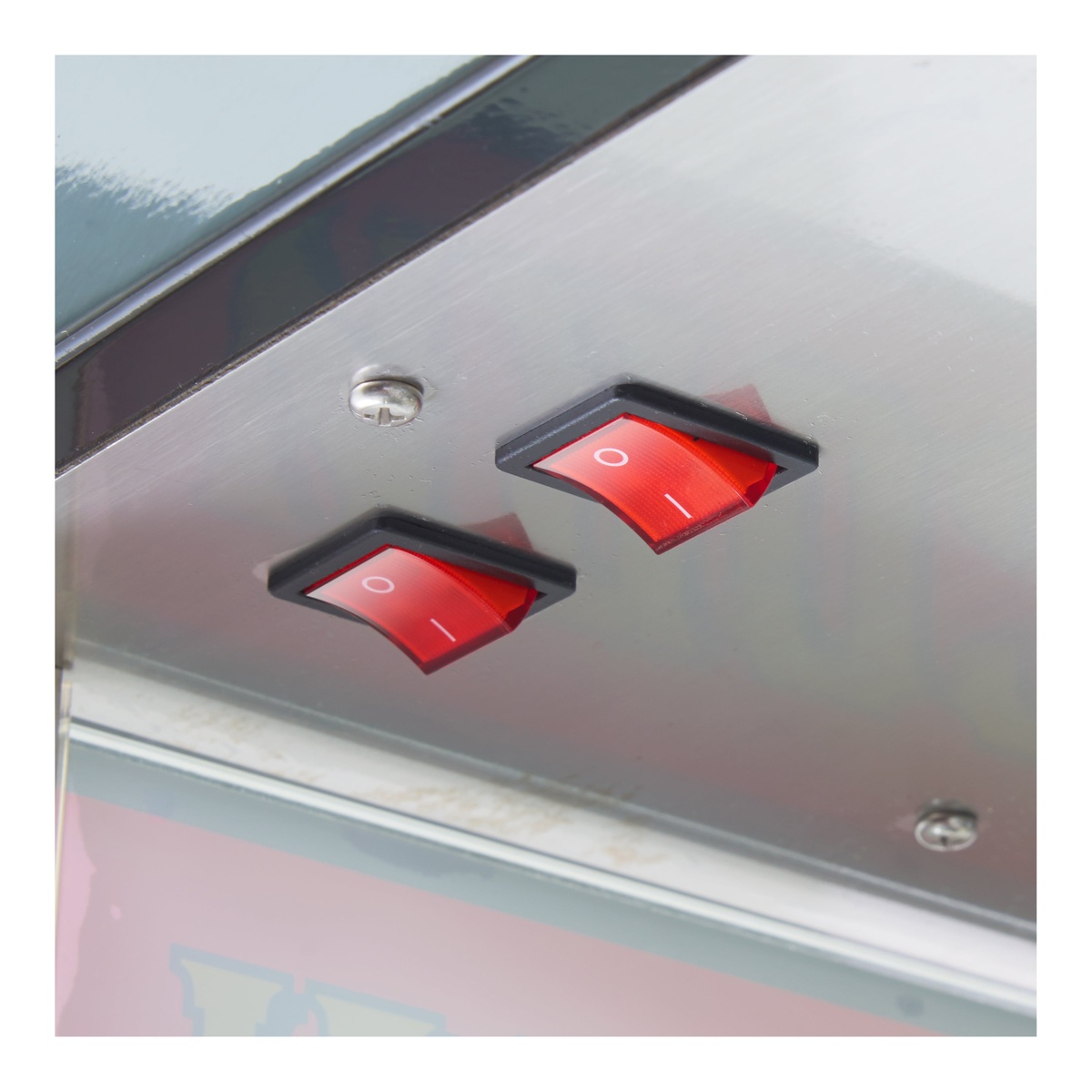 Close-up of two red rocker switches on popcorn machine control panel
