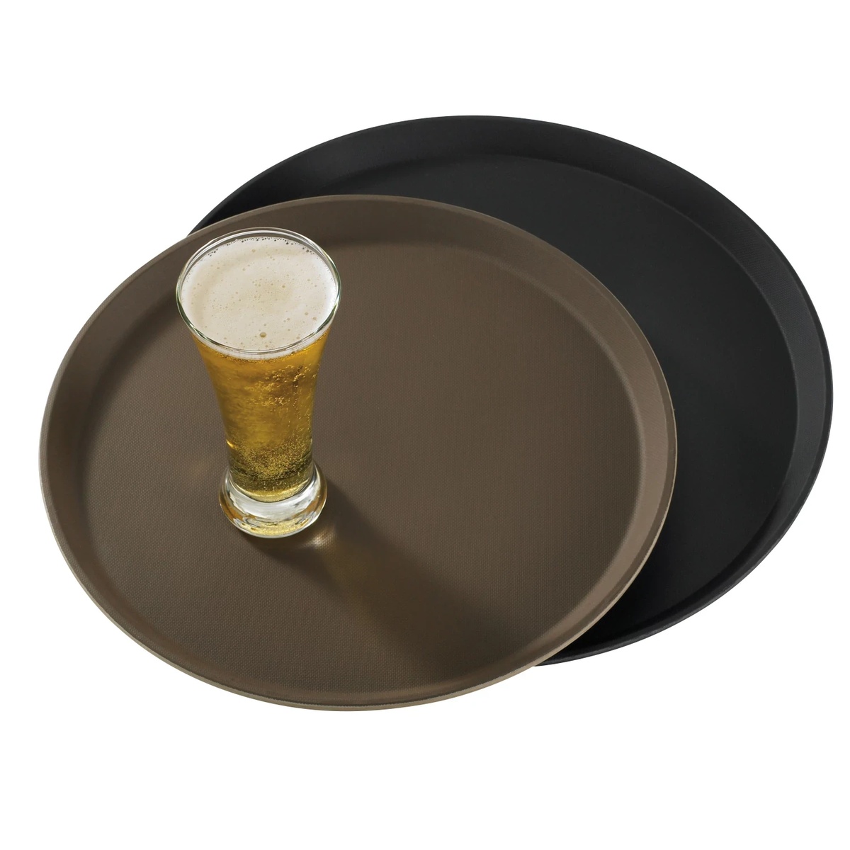 Two Cambro Treadlite round serving trays stacked together, one black and one tan, with a full pilsner glass resting securely on the non-skid surface