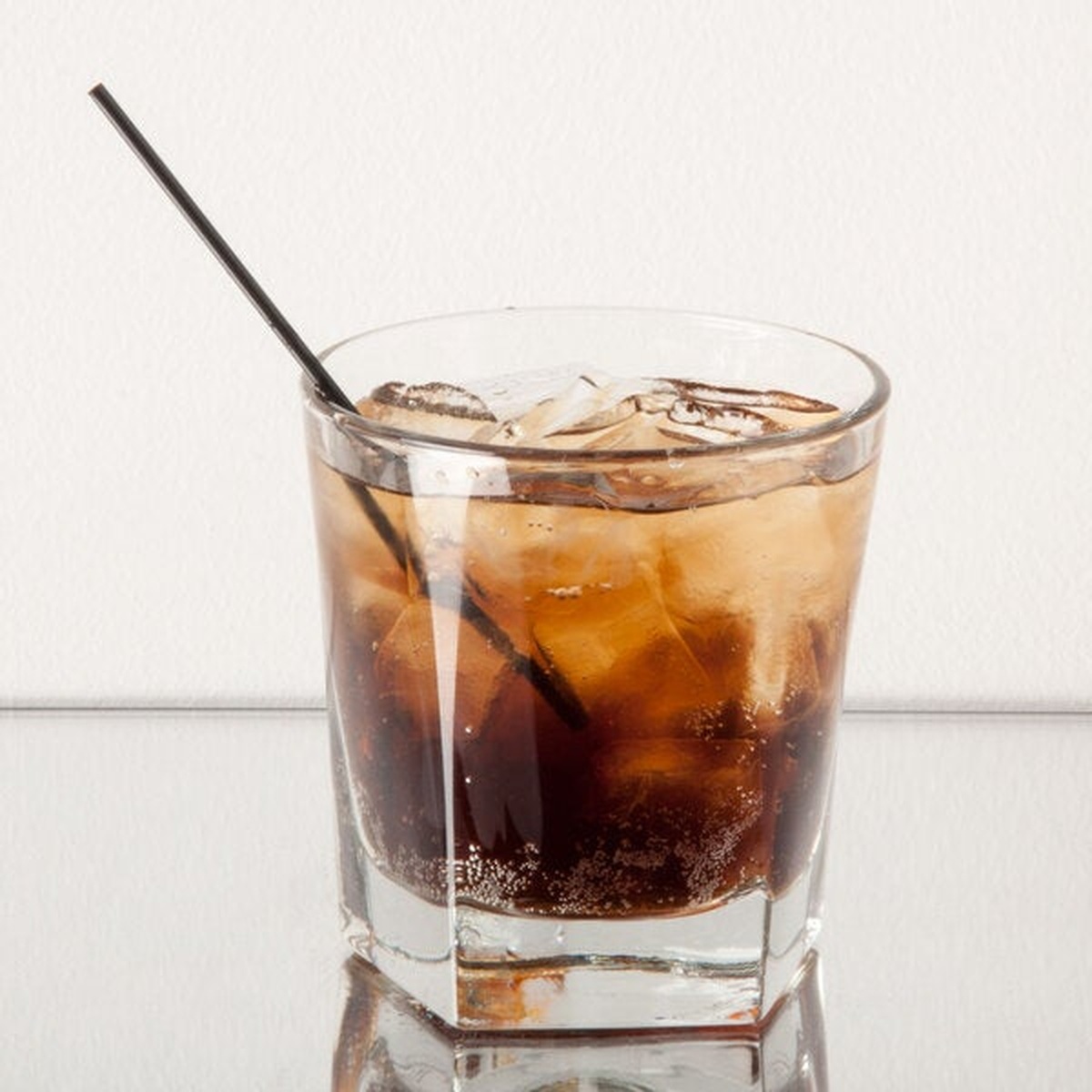 Libbey Inverness double old fashioned glass filled with a brown cocktail over ice with a straw