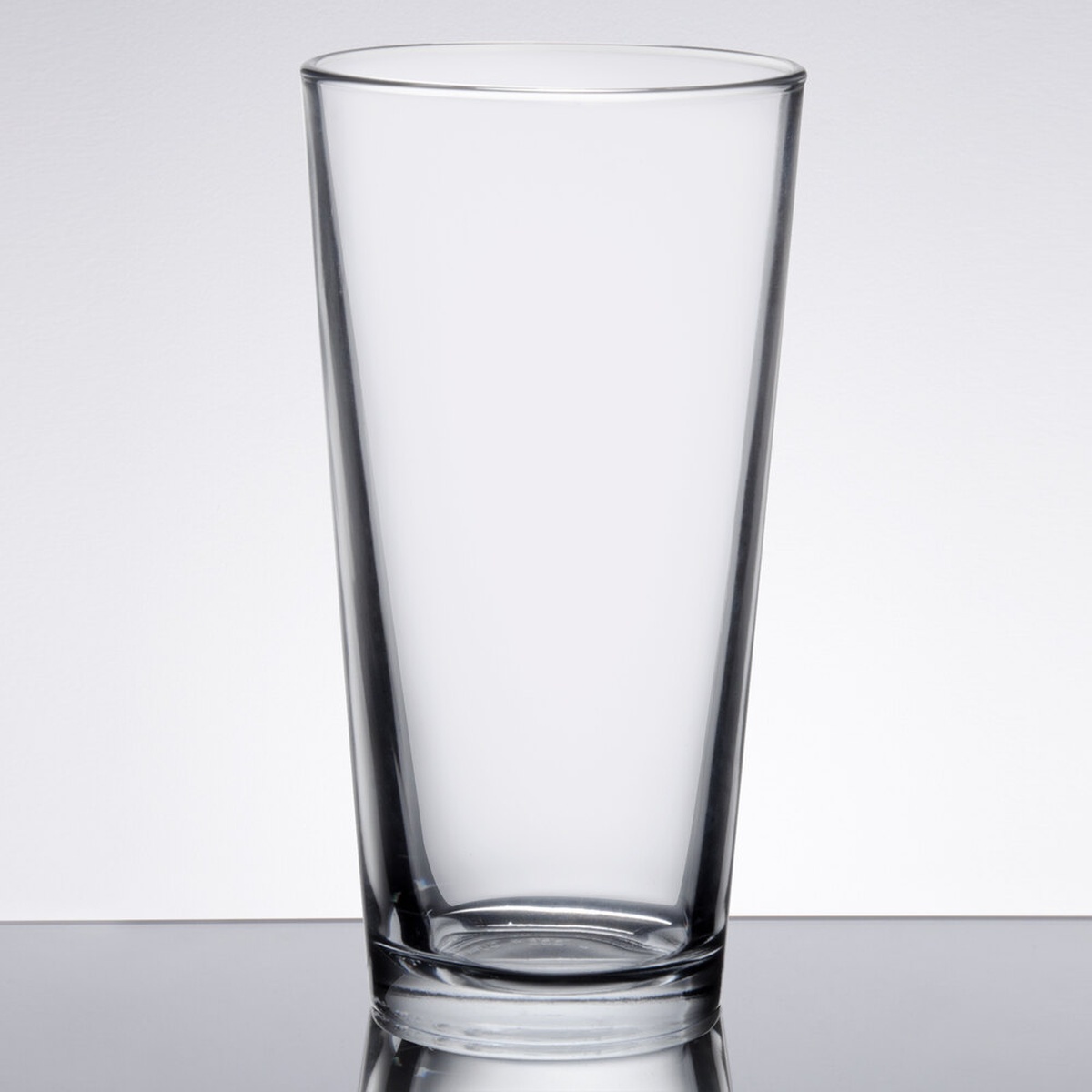Libbey 15722 22 oz. clear conical mixing glass on a reflective surface