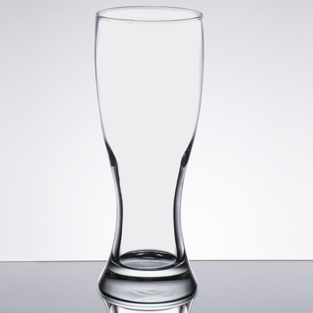 Libbey 1629 20 oz. Giant Pilsner Glass - clear glass with contoured hourglass shape and thick base on reflective surface