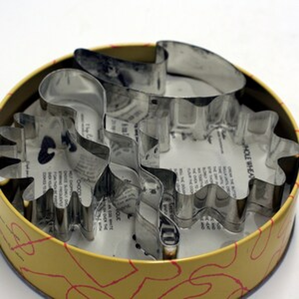 Open Kooky Cutters tin showing eight abstract metal cookie cutter forms inside