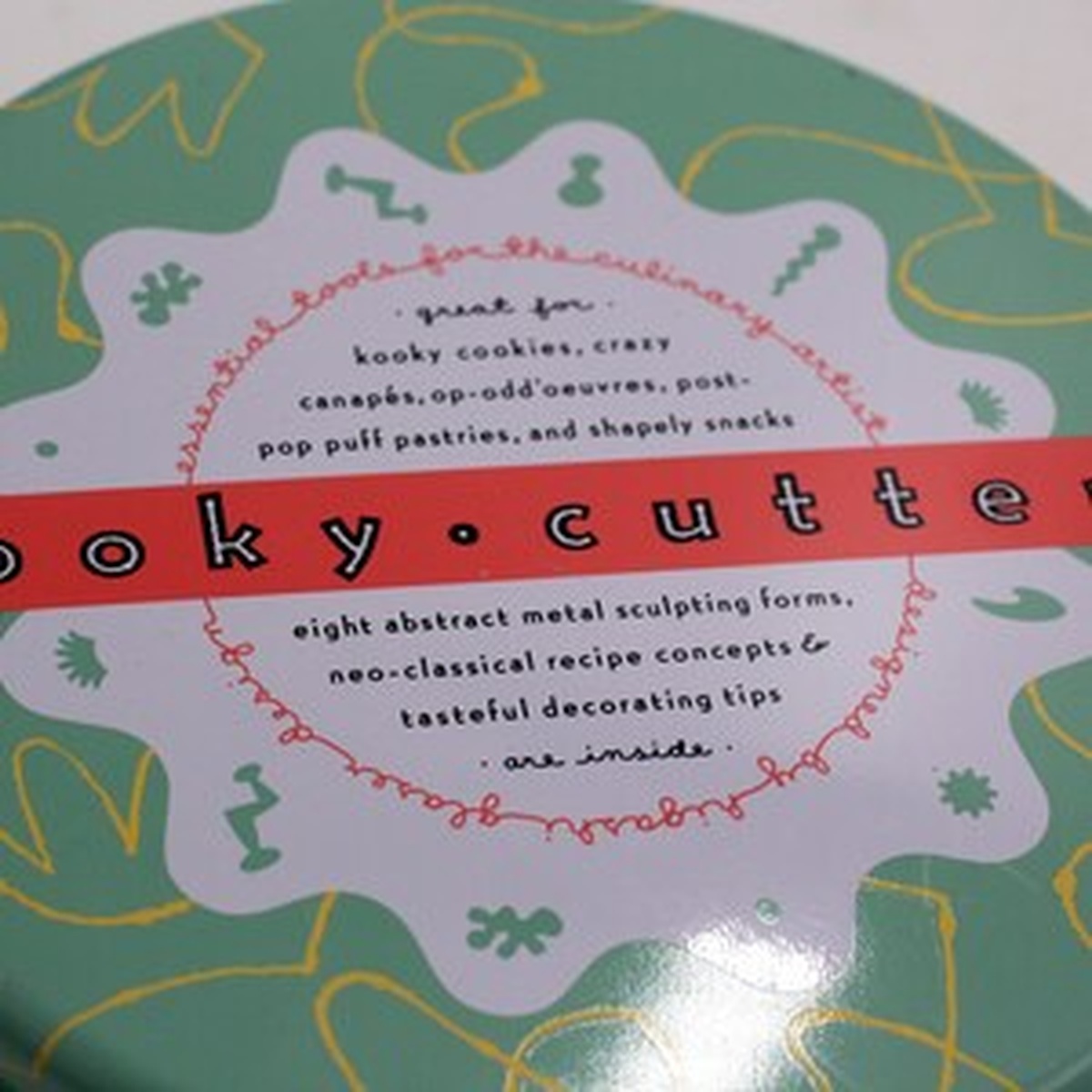 Close-up of Kooky Cutters tin lid showing branded red banner and descriptive text