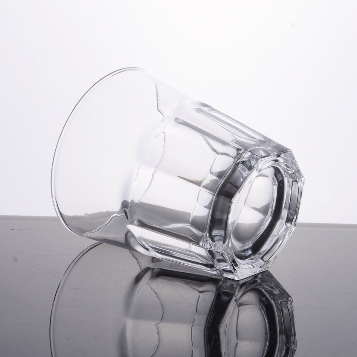 Enhanced Glassware 12 oz glass tumbler on its side showing detailed faceted base construction