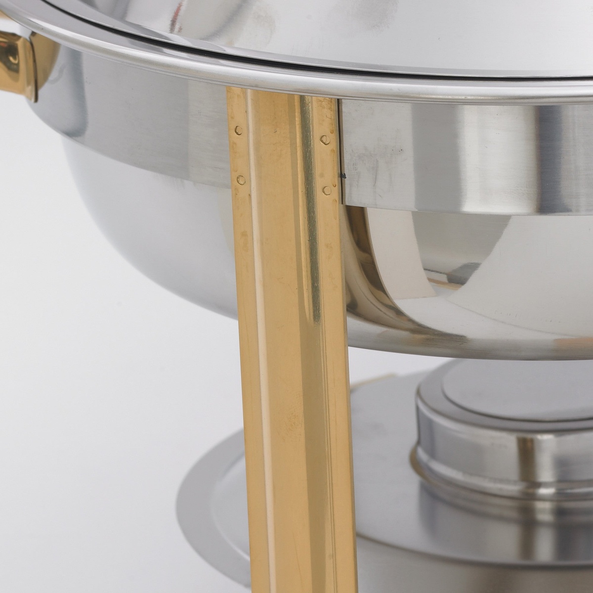 Close-up of the double-riveted gold-tone stand leg and sterno fuel holder of the Winco 203 chafing dish