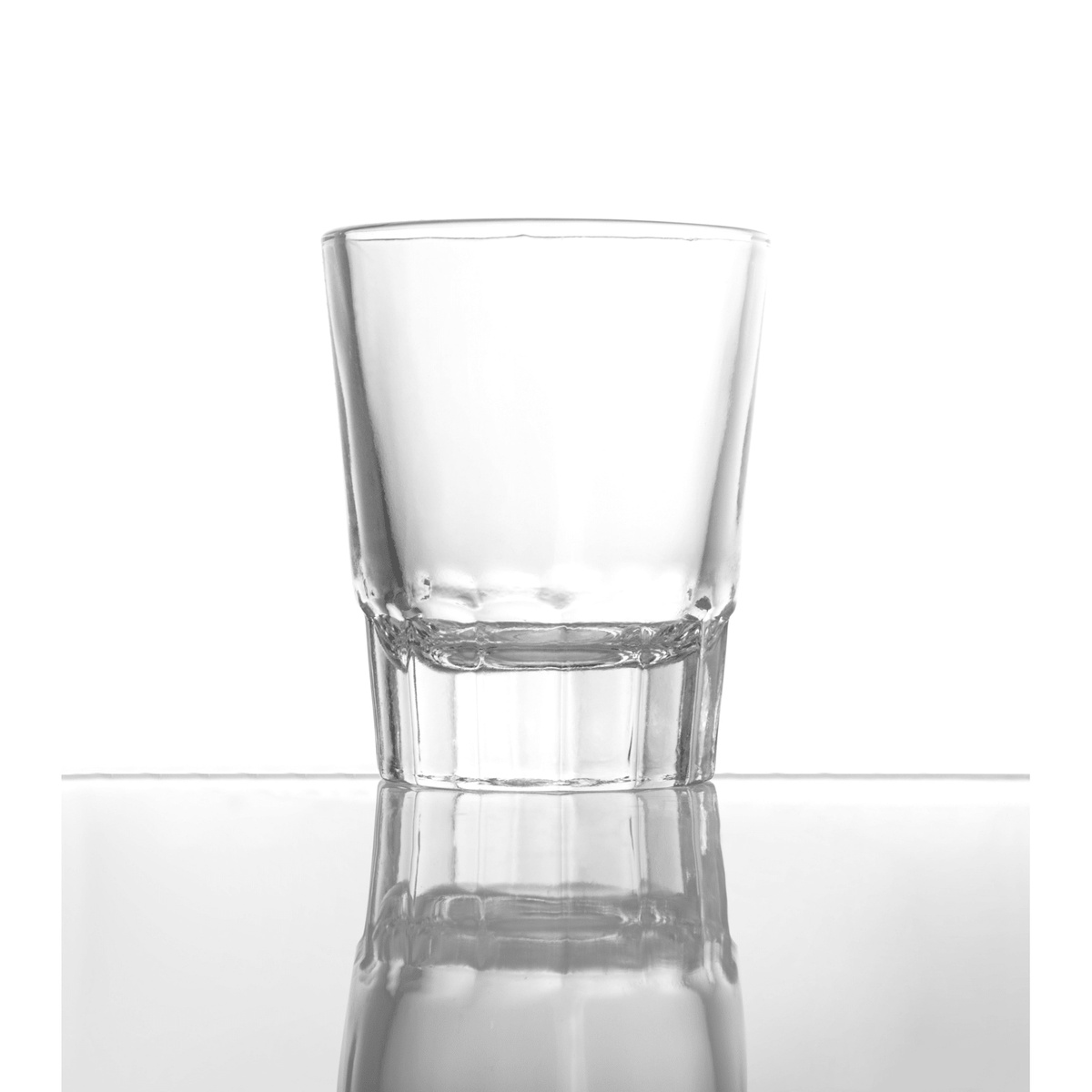 Enhanced 1.5 oz shot glass with thick base, clear glass, on reflective white surface