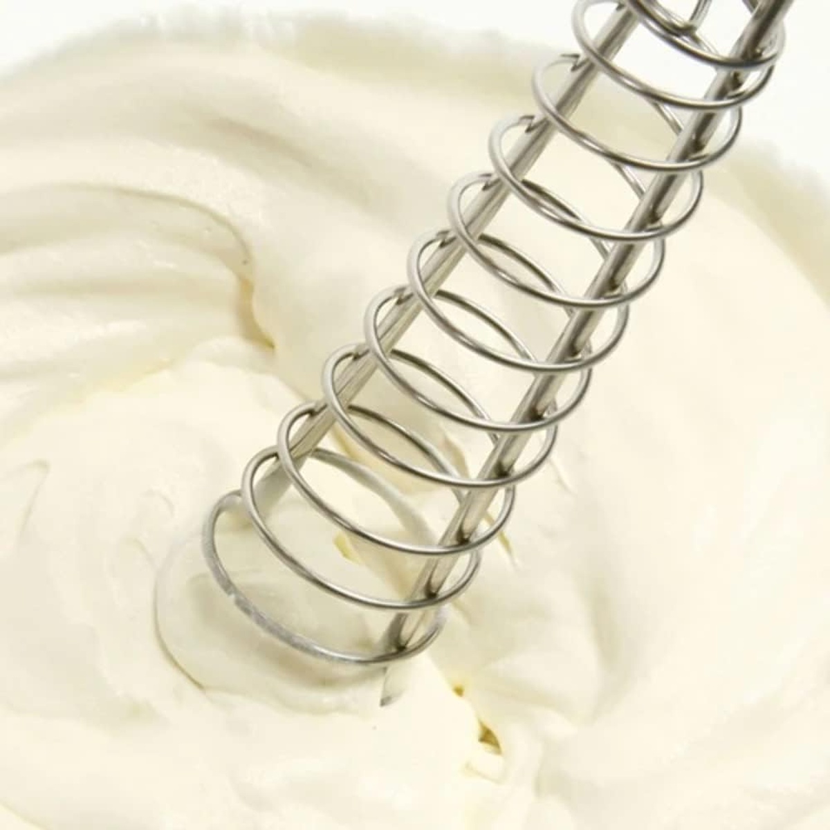 Close-up of the Norpro Saucinator whisk coil mixing thick cream or batter