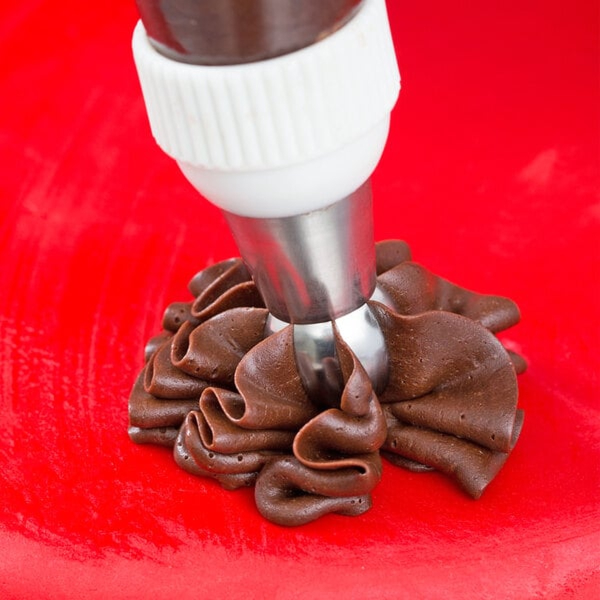 Ateco 272 piping tip creating a ruffled chocolate frosting flower design