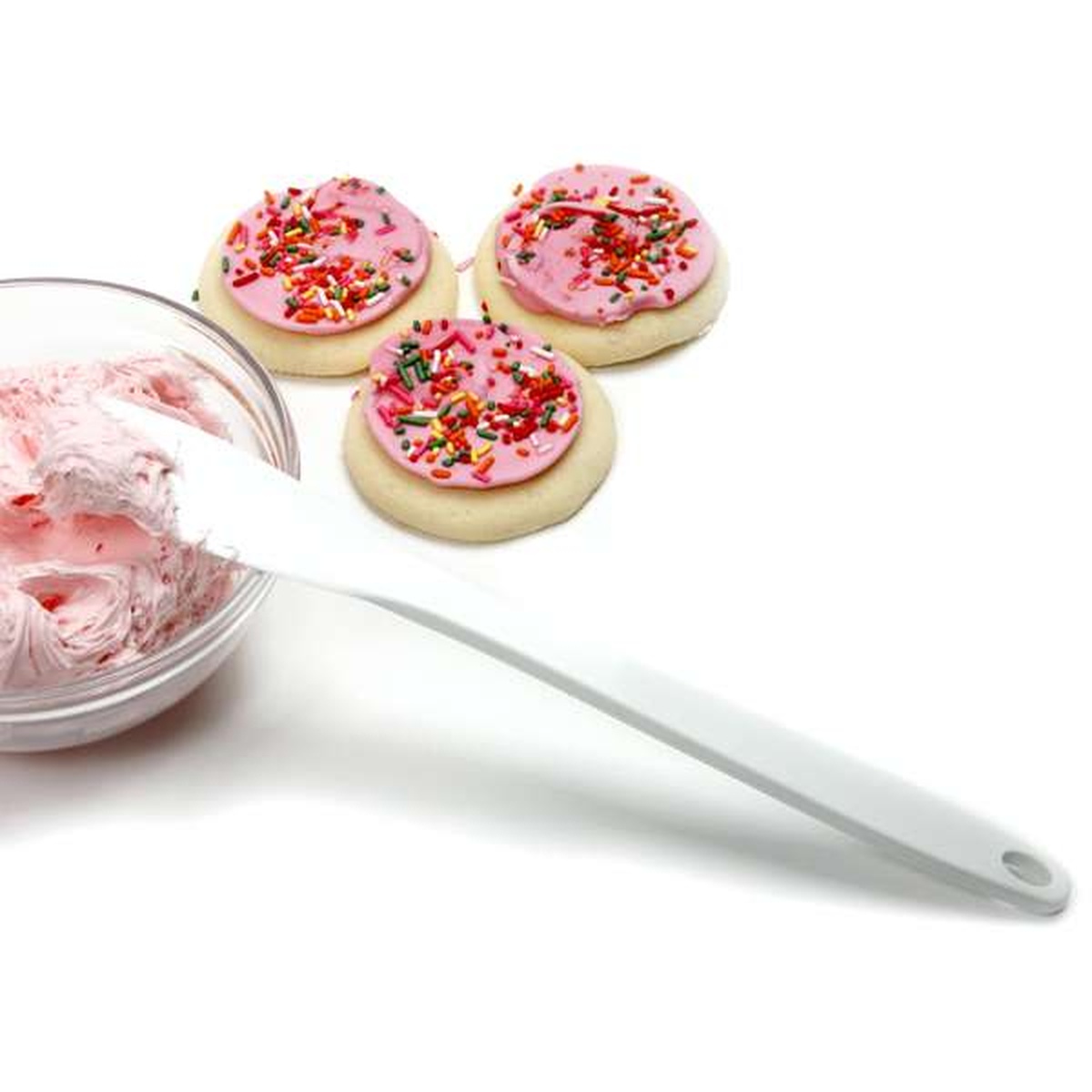 Norpro spatula scraper shown close-up next to a bowl of pink frosting and decorated sugar cookies