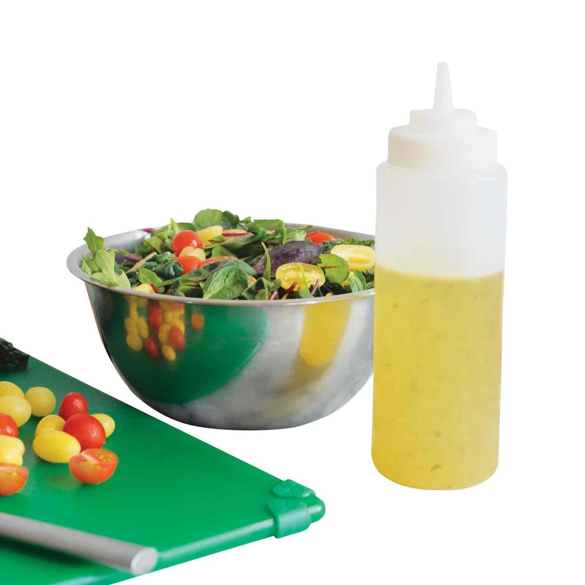 TableCraft 16 oz Widemouth squeeze bottle filled with dressing alongside a salad bowl and green cutting board