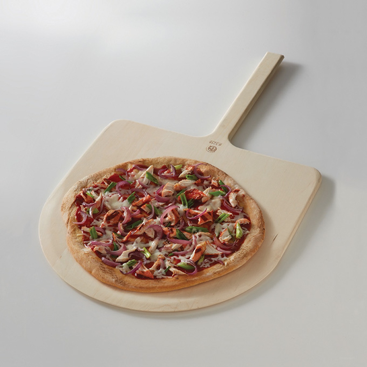 American Metalcraft 3218 wooden pizza peel holding a fully topped pizza with onions and peppers