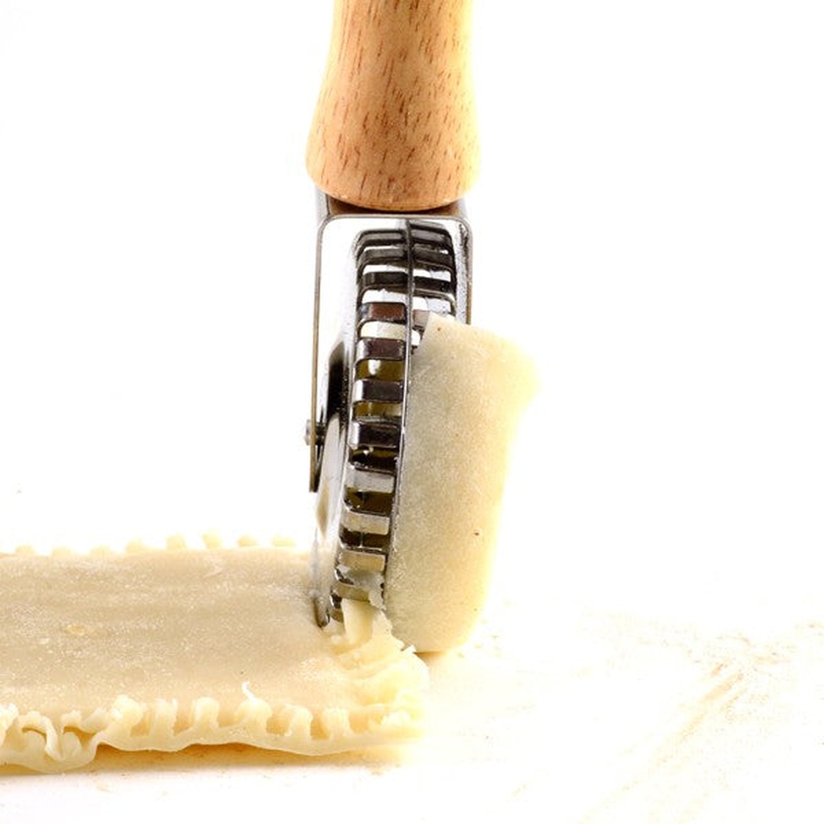 Close-up of Norpro 3248 stainless steel crimping wheel rolling along the edge of raw pasta dough