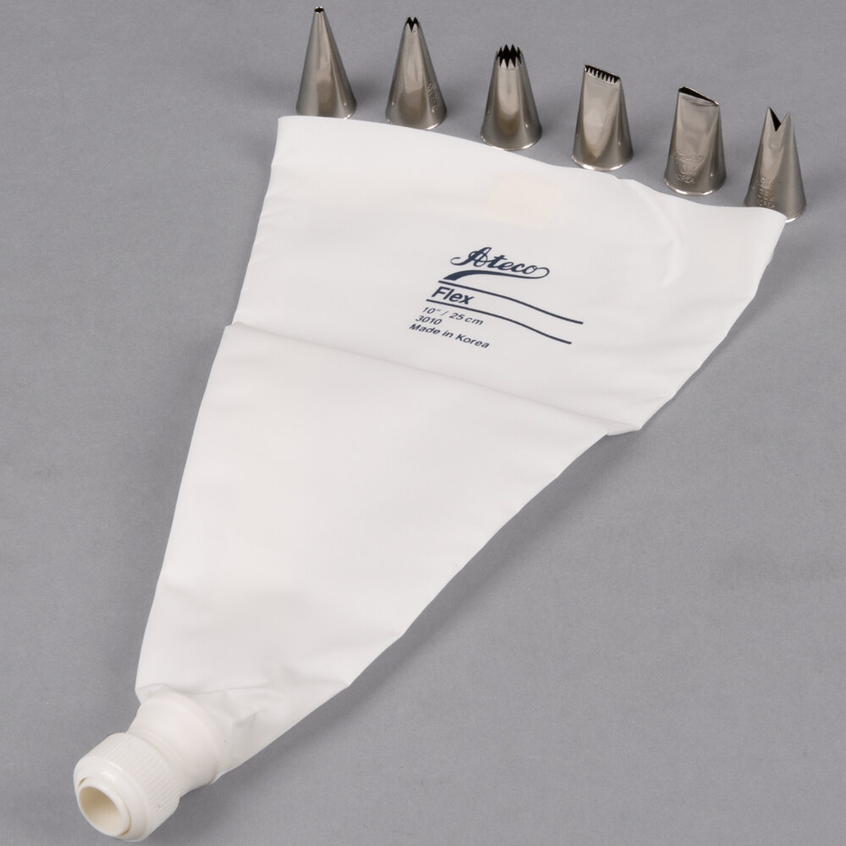 Ateco 334 8-piece decorating set with six stainless steel piping tips and white flex pastry bag laid flat