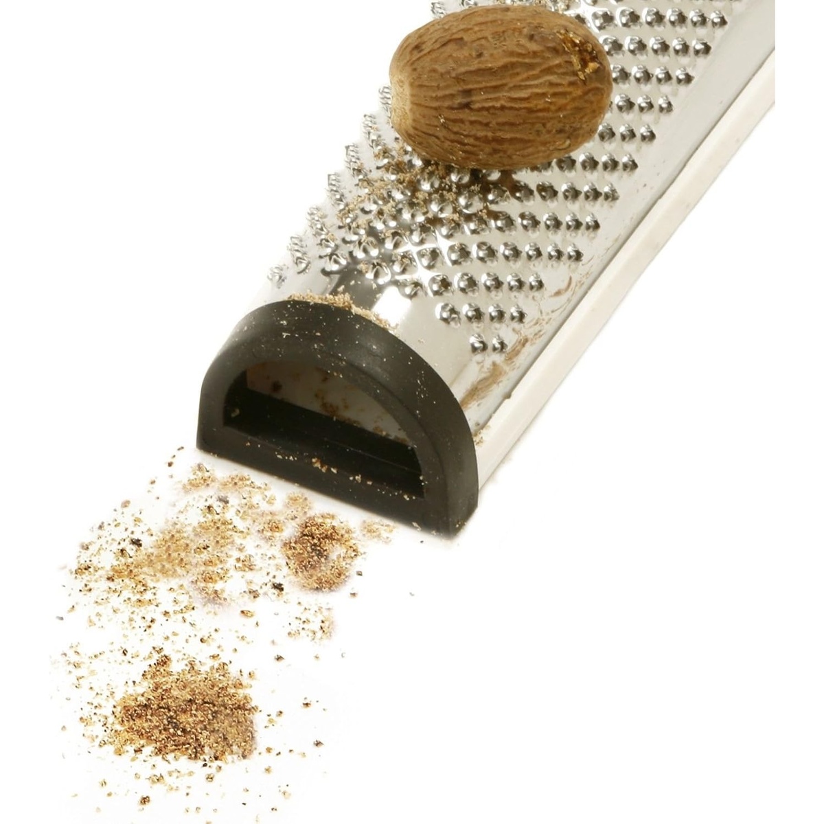 Close-up of Norpro nutmeg grater with a whole nutmeg resting on the grating surface and freshly ground nutmeg powder below