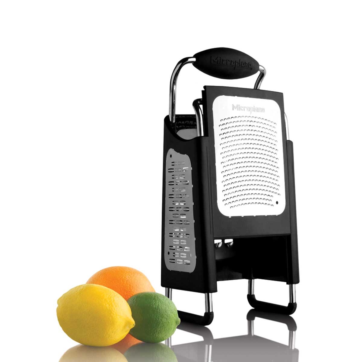Microplane 4-Sided Box Grater displayed upright alongside lemon, orange, and lime, highlighting fine and ribbon blade sides