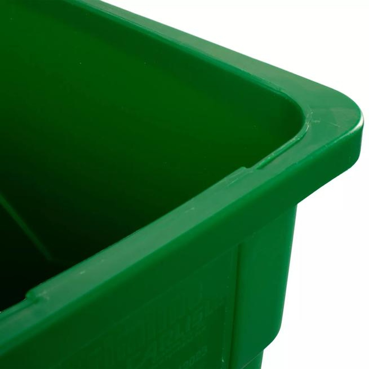 Close-up of green compost container interior corner showing smooth surface and integrated liner tab detail
