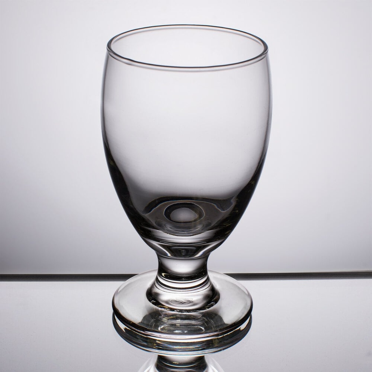 Libbey Embassy 3752HT clear banquet goblet with thick stem and wide bowl on reflective surface