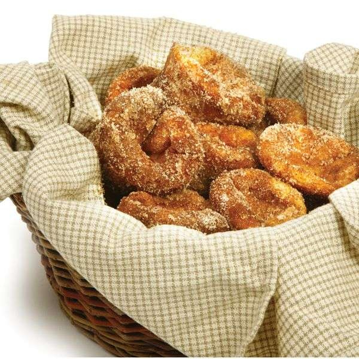 Basket lined with a cloth napkin filled with golden cinnamon-sugar coated popovers