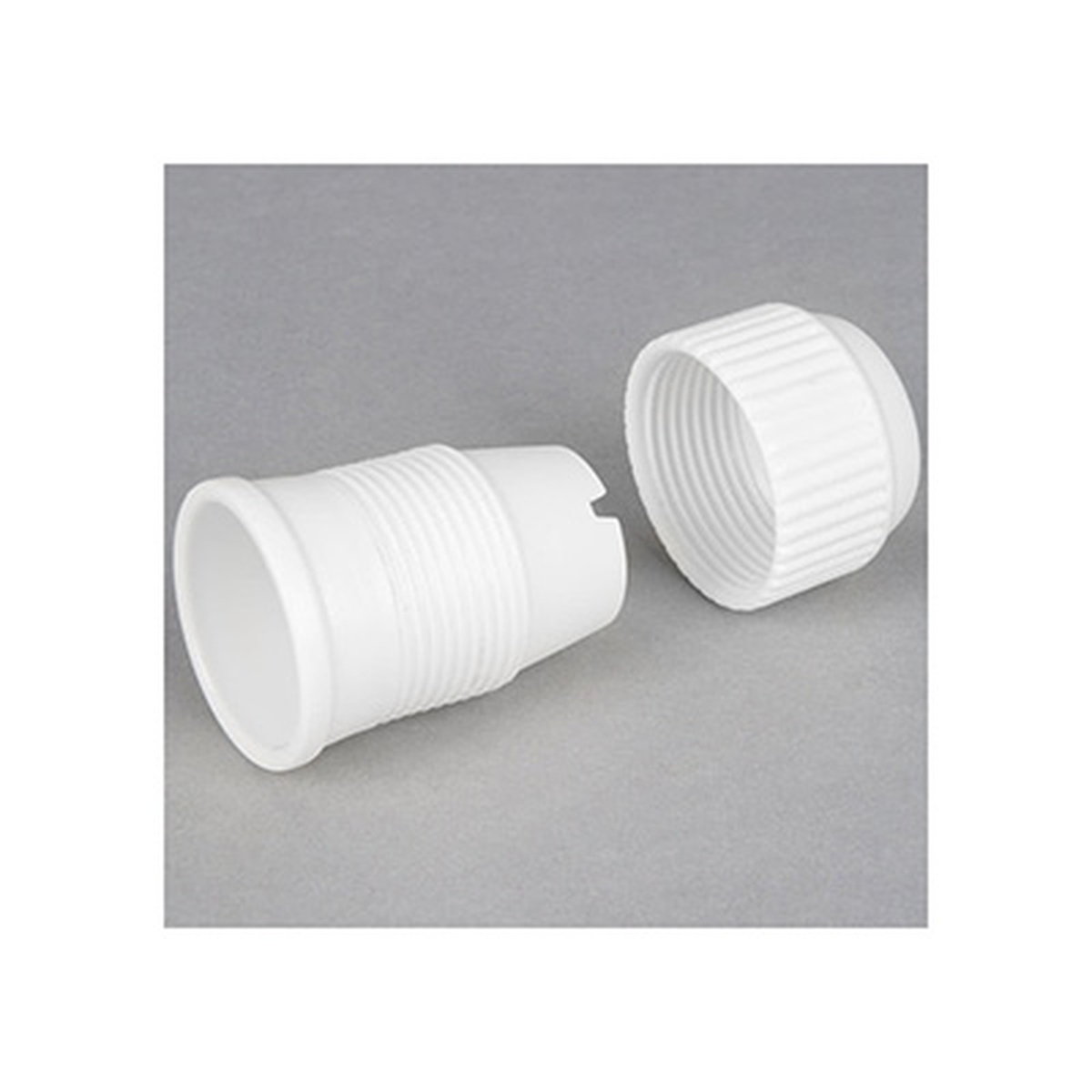 Ateco 404 coupler shown disassembled into two white plastic pieces: base and ridged ring