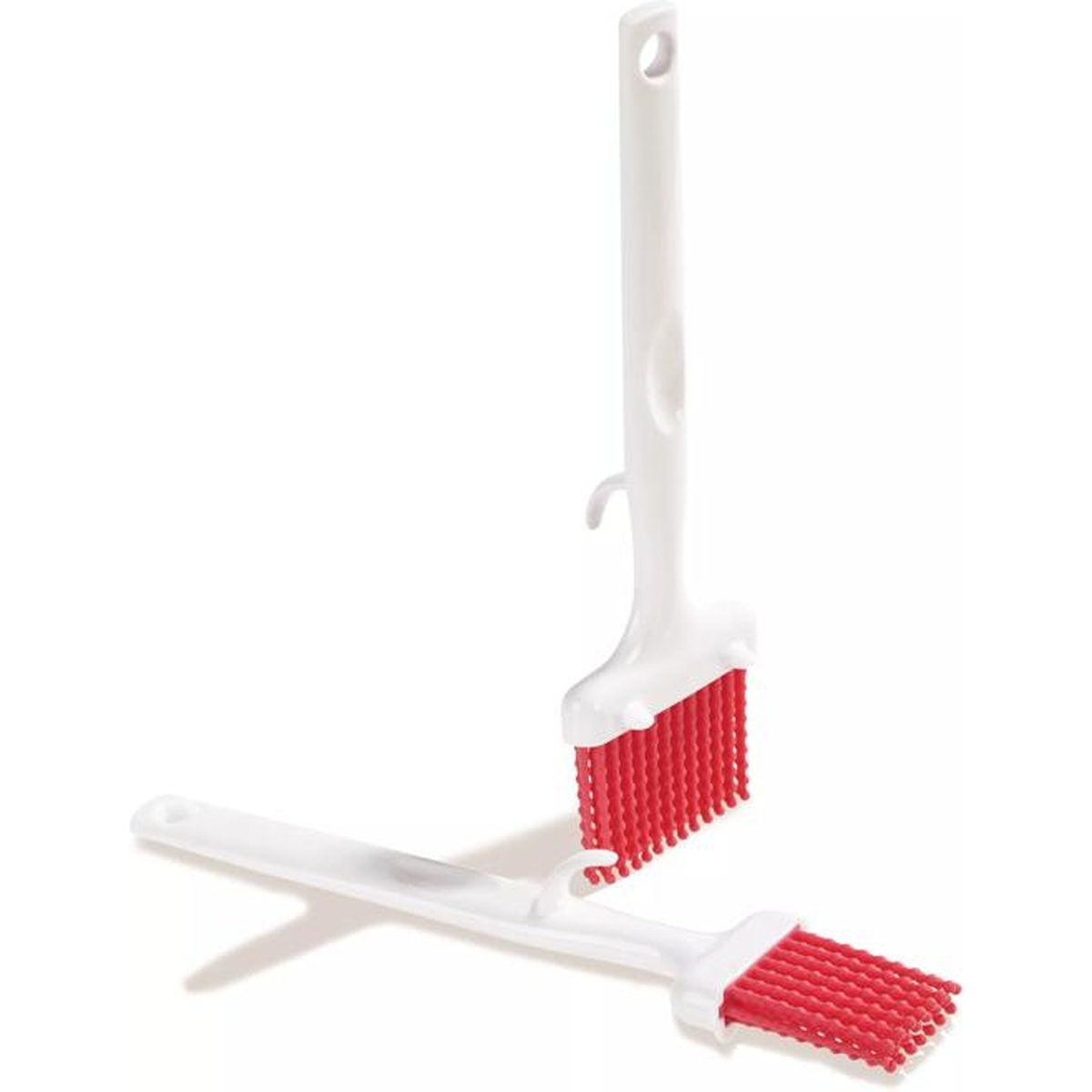 Two Carlisle red silicone pastry brushes standing upright showing hook and bristle design