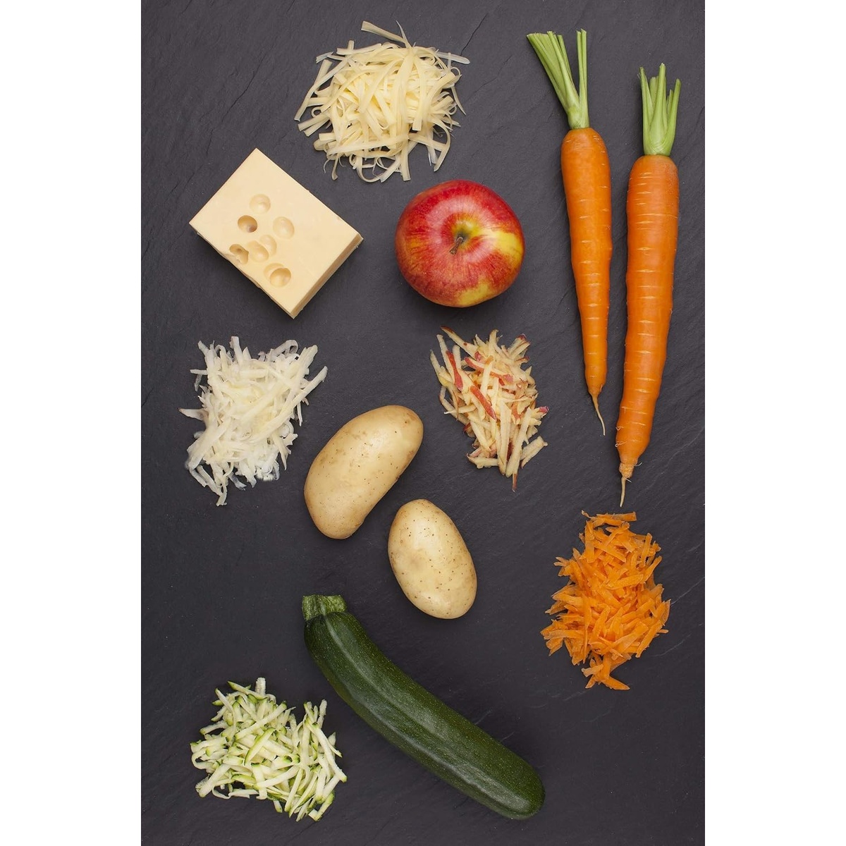 Assortment of foods compatible with the extra coarse grater including cheese, carrots, apple, zucchini, and potatoes with piles of shredded results