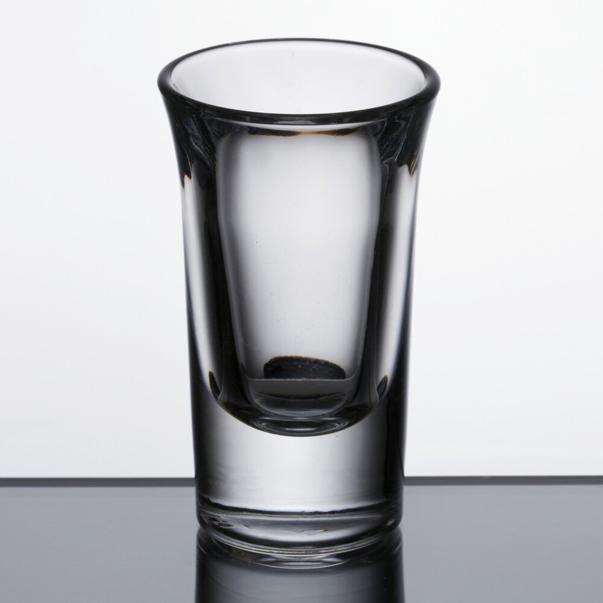 Libbey 5031 1 oz. tall shot glass shown from the front on a reflective surface