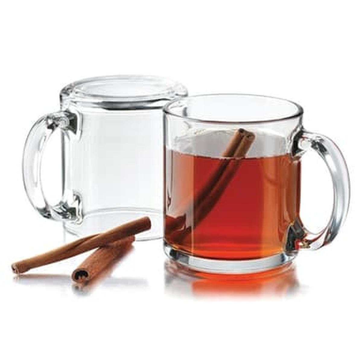 Two Libbey 5213 glass mugs side by side, one filled with tea and a cinnamon stick, with cinnamon sticks in foreground