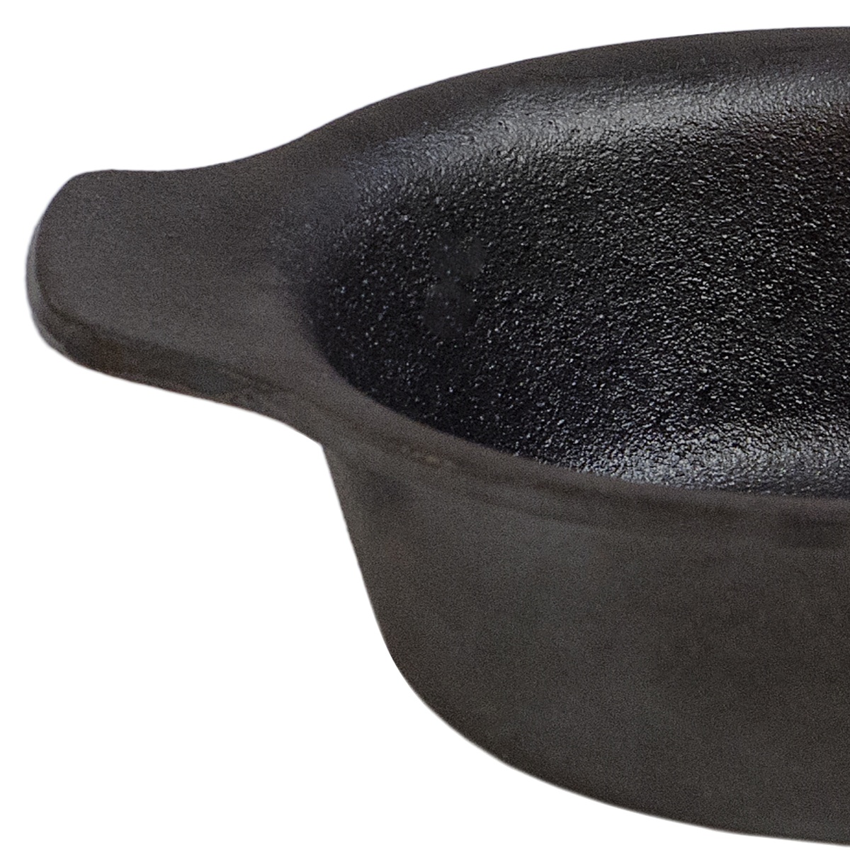 Close-up detail of the pre-seasoned black cast iron textured surface and handle of the Browne Thermalloy mini oval casserole
