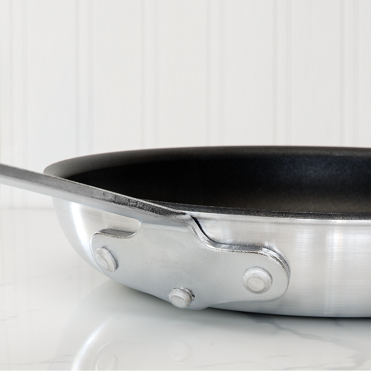Close-up of off-set riveted handle attachment and Eclipse non-stick interior of Browne Thermalloy fry pan