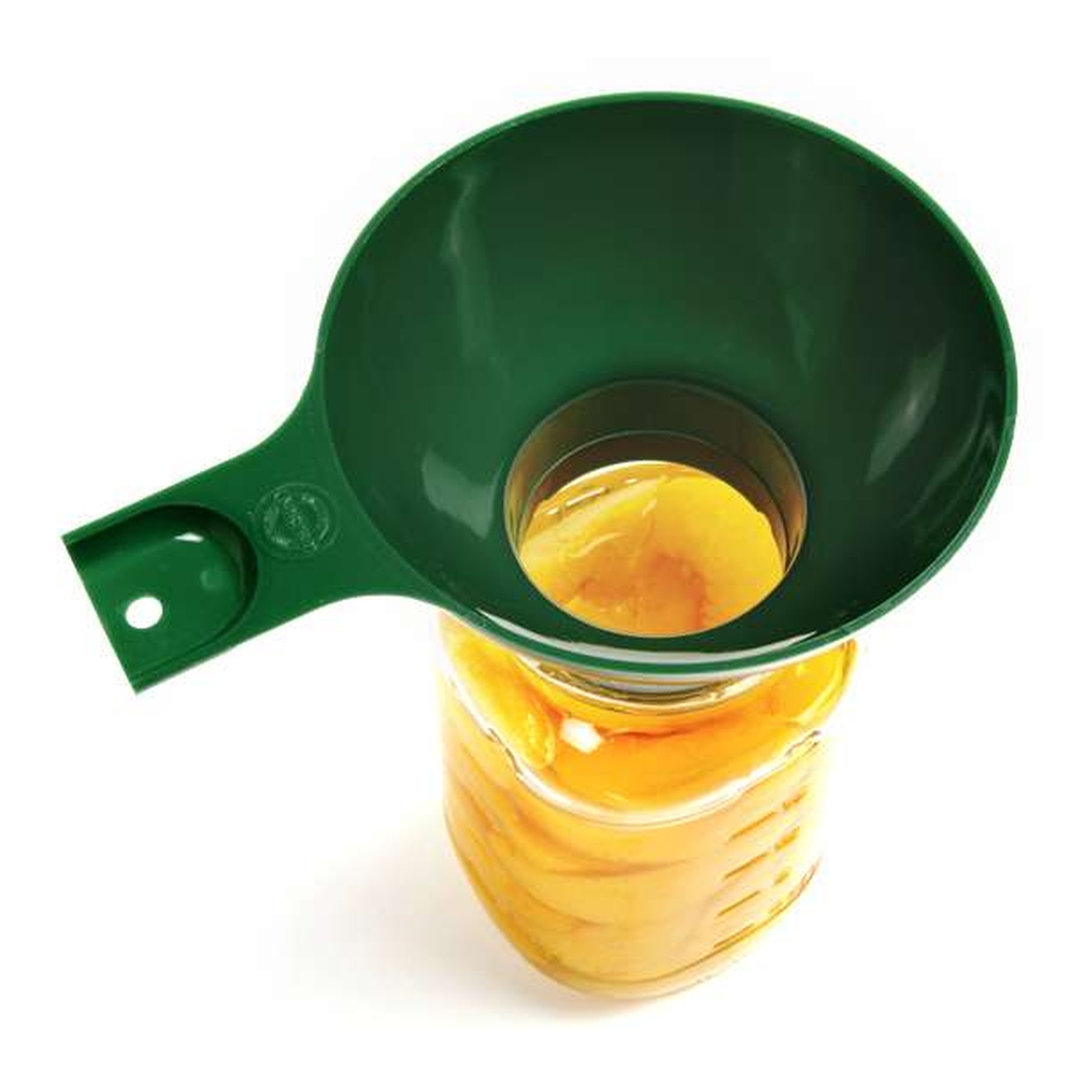Norpro 607 green canning funnel placed on top of a wide mouth mason jar filled with peaches