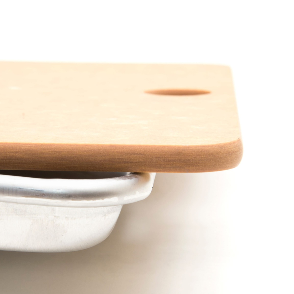 Close-up of Epicurean sheet pan board edge resting on a sheet pan rim, showing composite wood thickness
