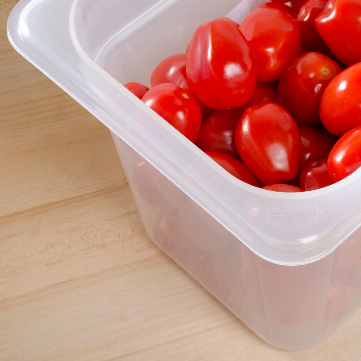 Close-up view of the Cambro 66PP190 translucent food pan corner detail filled with cherry tomatoes