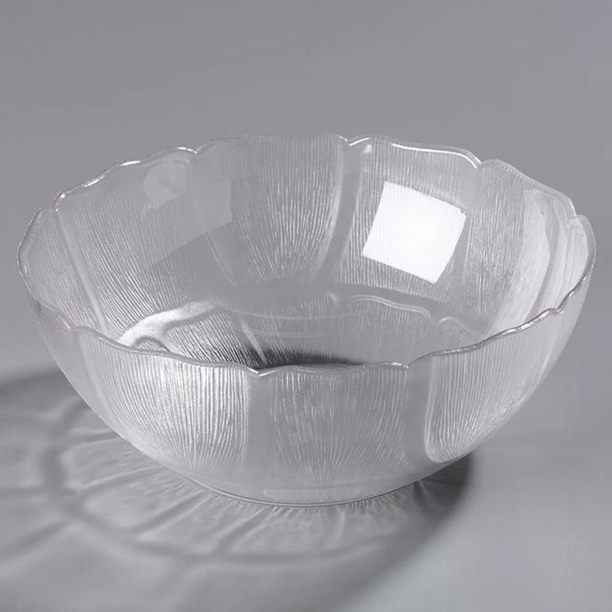 Carlisle Petal Mist clear bowl against gray background, showing full form and scalloped rim detail