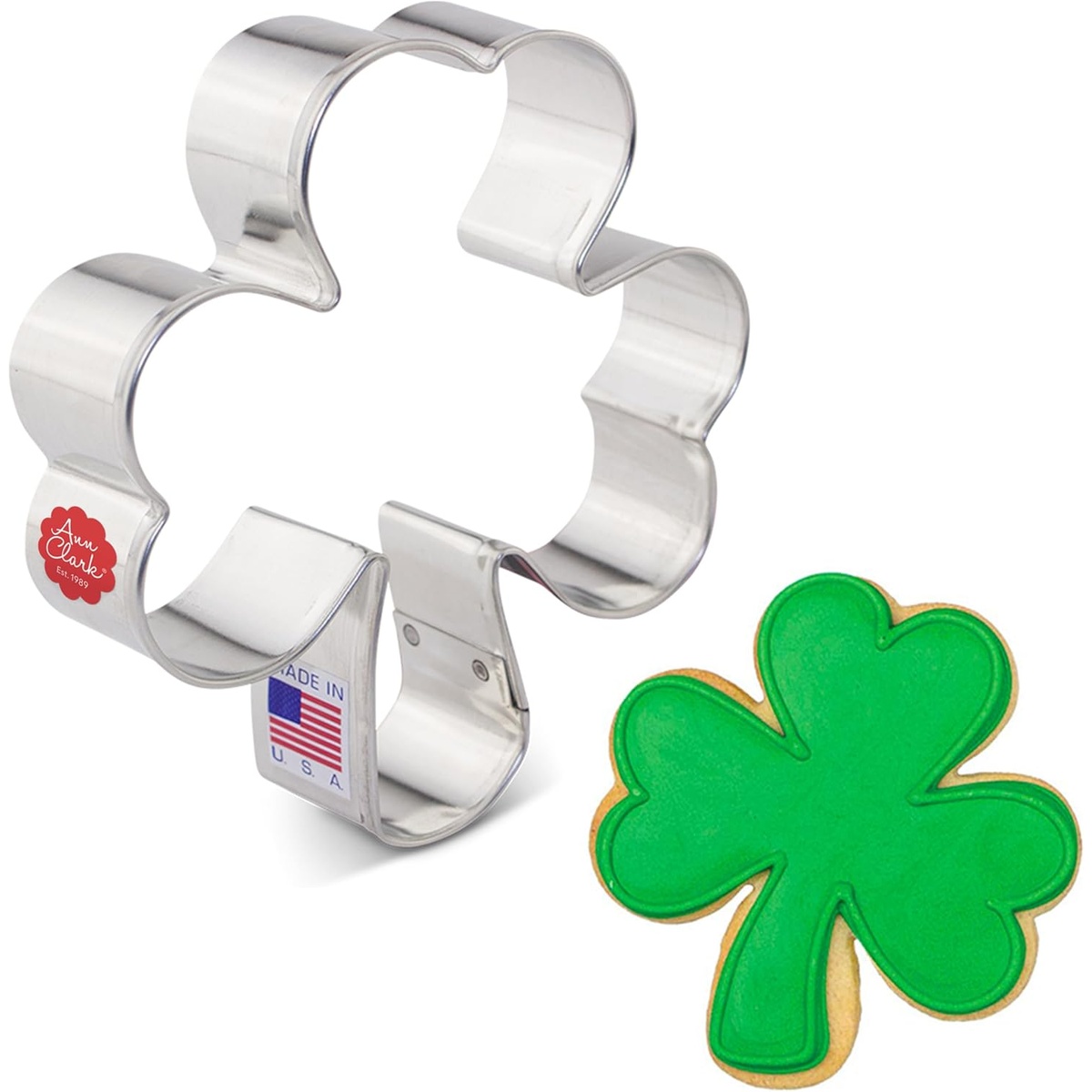 Ann Clark shamrock cookie cutter in stainless steel beside a finished green-frosted shamrock cookie