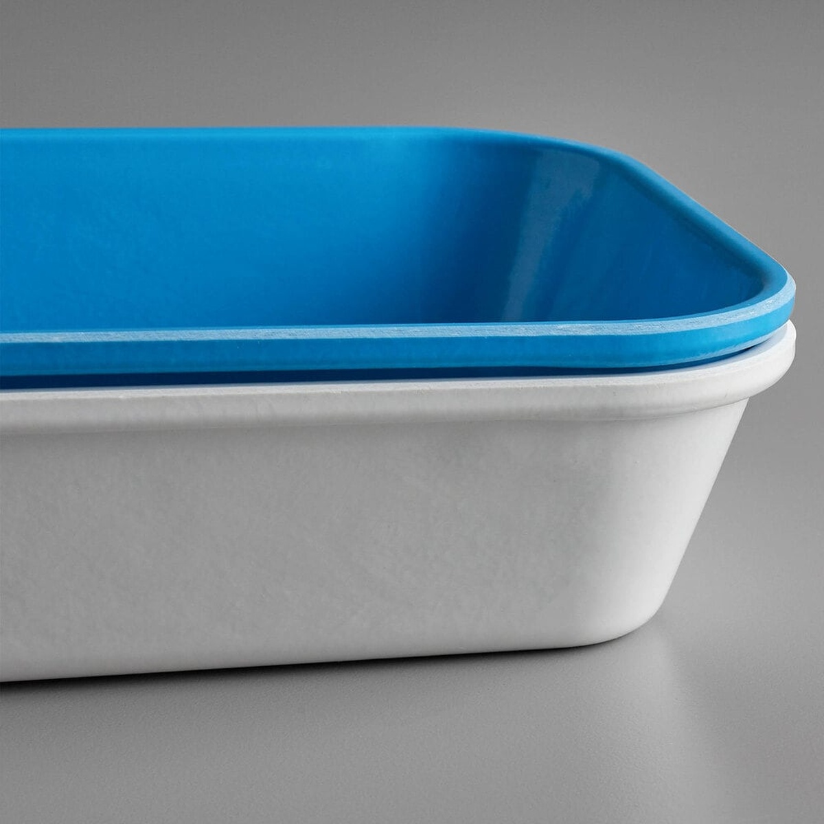 Close-up of white and blue Cambro fiberglass market pans stacked together, showing the Dri-Stak stacking lug separators