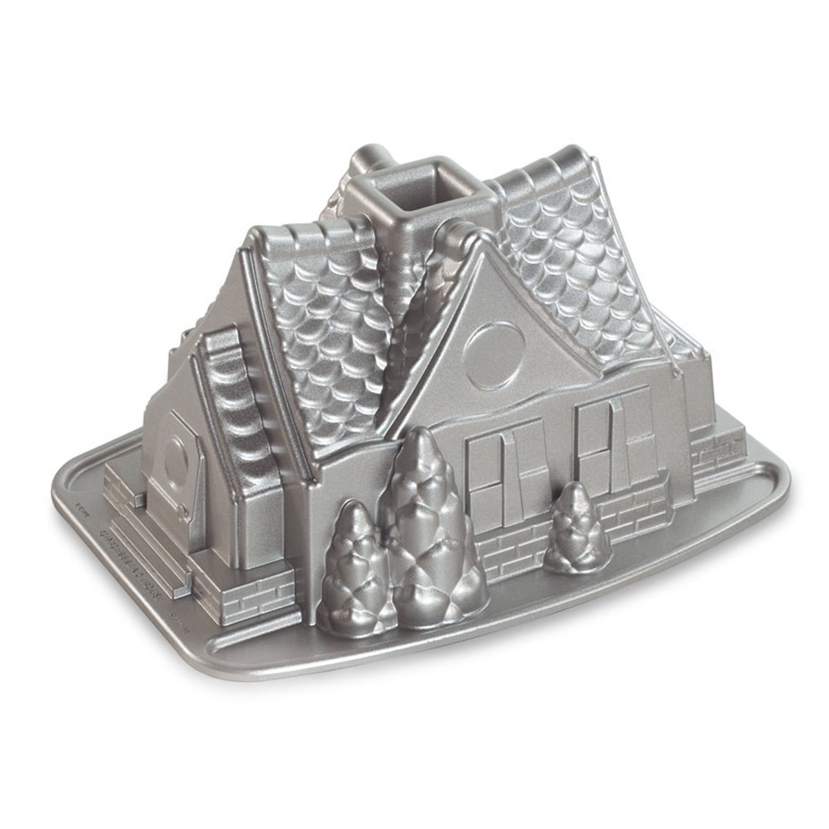 Nordic Ware Gingerbread House Bundt Pan in silver cast aluminum showing shingled roof, brick foundation, and decorative evergreen trees