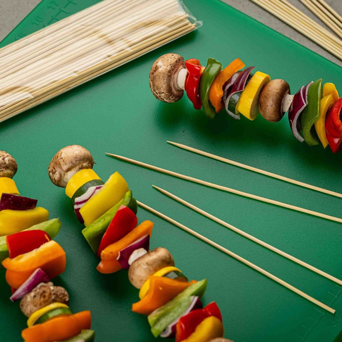 Close up of bamboo skewers holding colorful vegetable kabobs