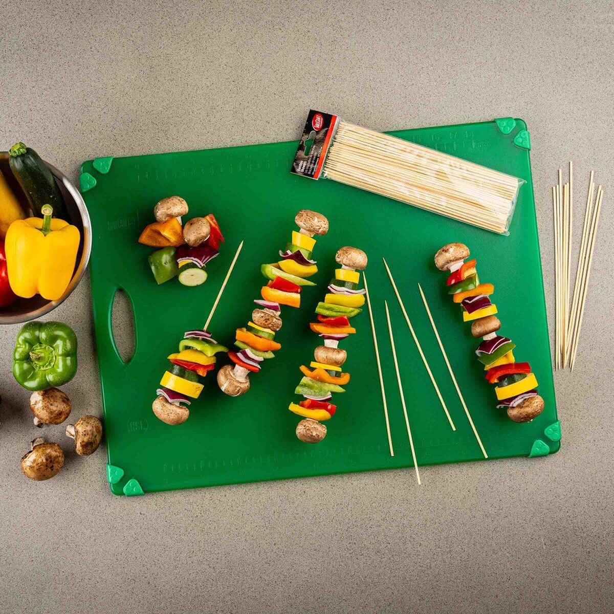 Overhead view of bamboo skewers and prepared vegetable skewers on a cutting board
