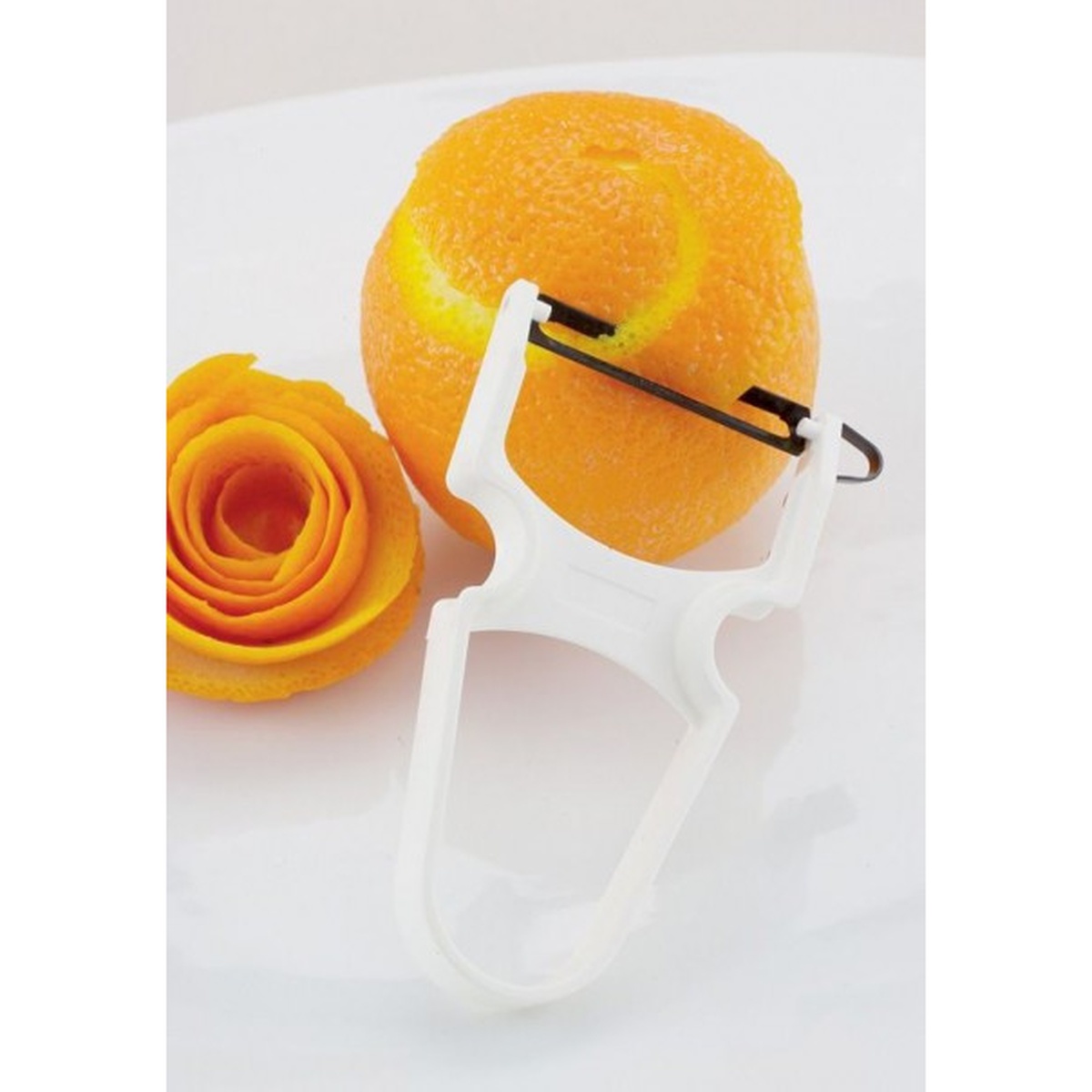 Dexter Russell 91500 white Y-style Swiss peeler with high-carbon steel blade next to a peeled orange and decorative orange peel garnish