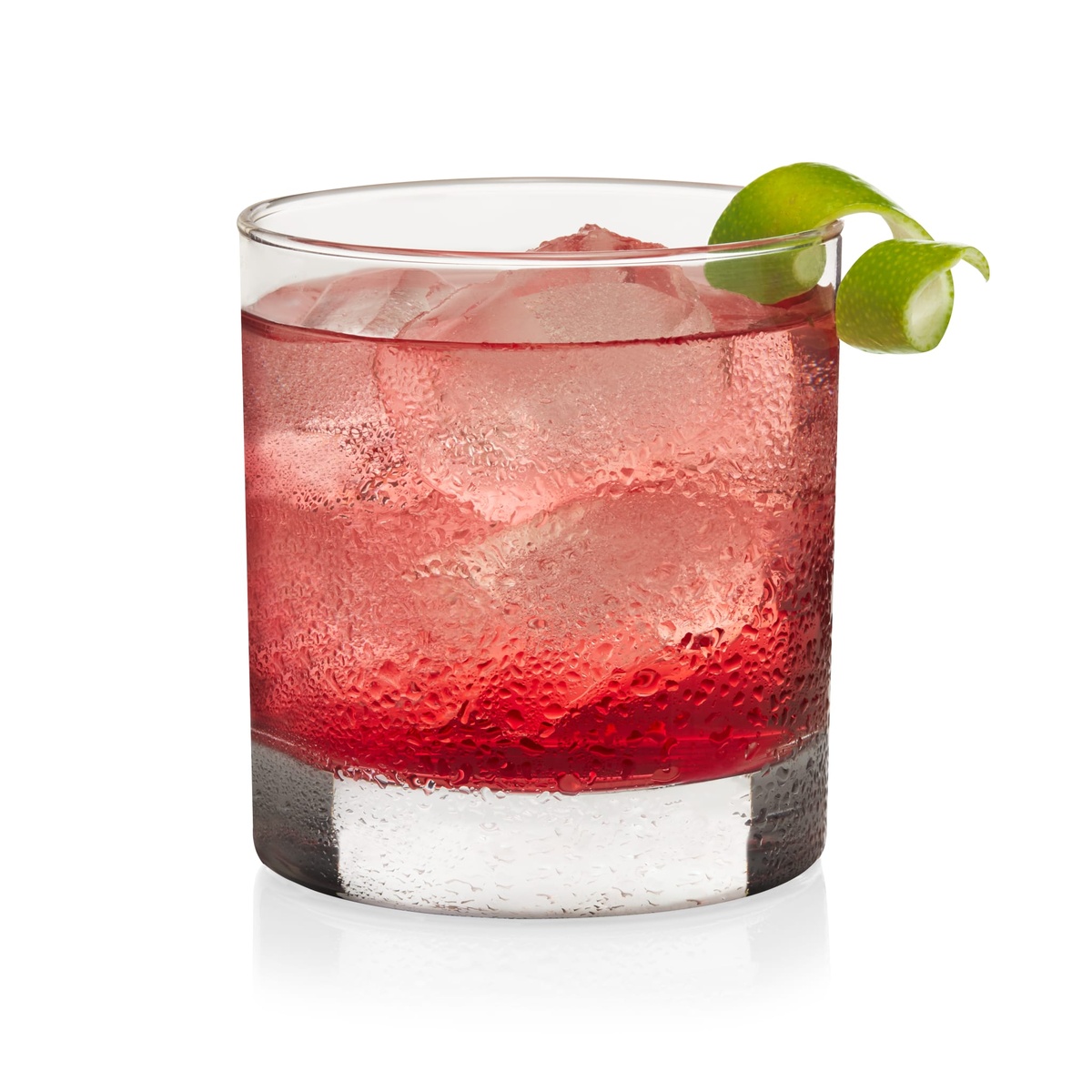 Libbey 917CD Heavy Base Rocks Glass filled with red cocktail and ice, garnished with a lime twist, on white background
