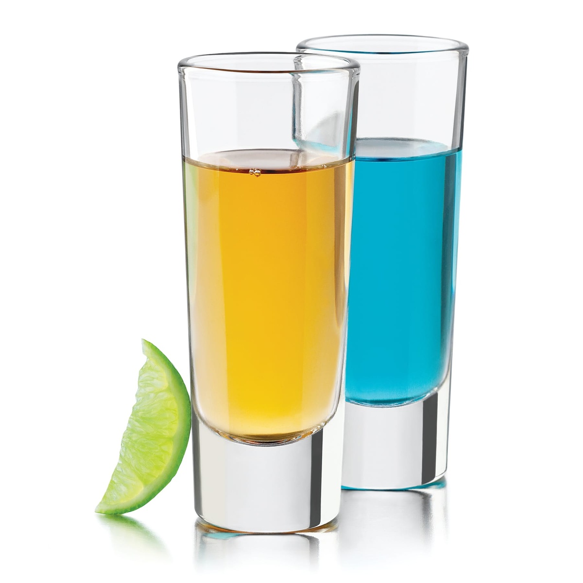 Two Libbey tequila shooter glasses filled with amber and blue spirits alongside a lime wedge