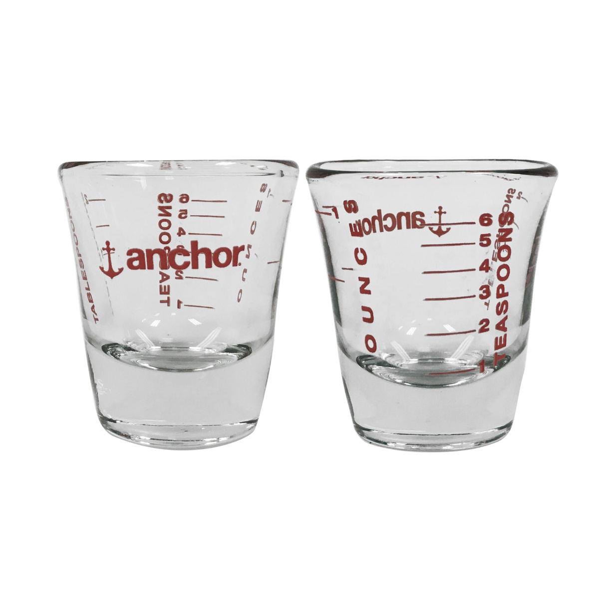 Anchor Hocking 96522AHG18 1 oz. kitchen shot glass shown from two angles displaying red teaspoon, tablespoon, and ounce graduation markings on clear glass
