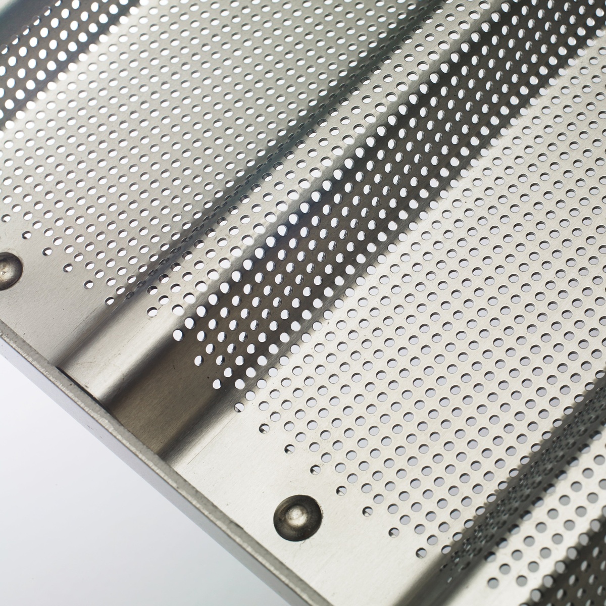 Close-up of the perforated aluminum surface and channel divider on the Winco ABPN-5H bread pan